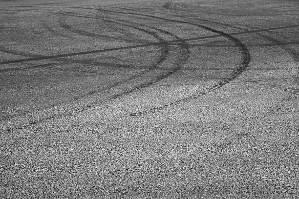 istock Dark tire tracks on gray asphalt road 531984602