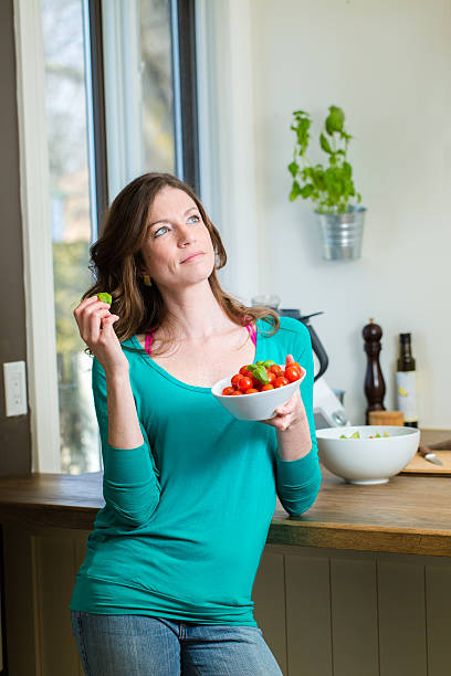 Young woman showing a cherry tomatoes