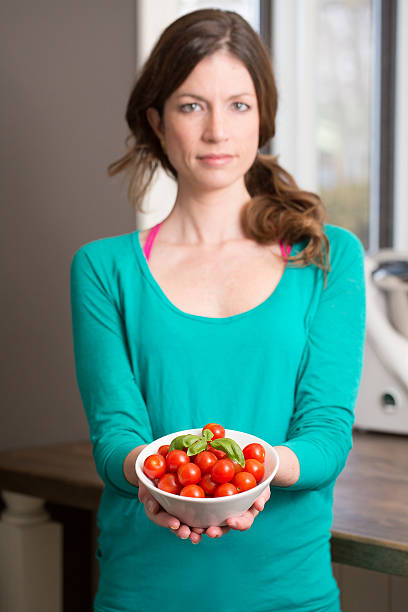 Young woman showing a cherry tomatoes
