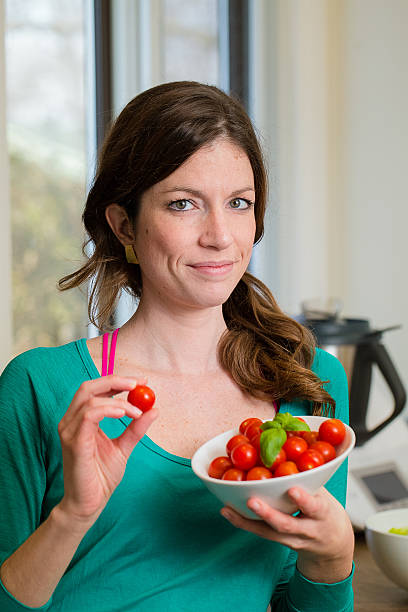 Young woman showing a cherry tomatoes