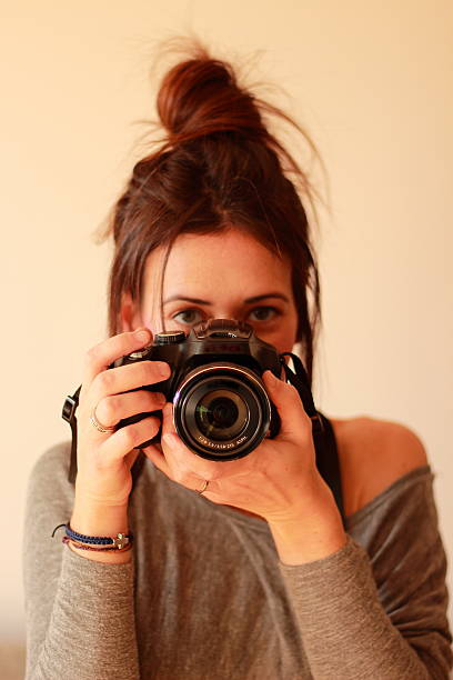 istock Young female photographer with camera on soft background 531986661