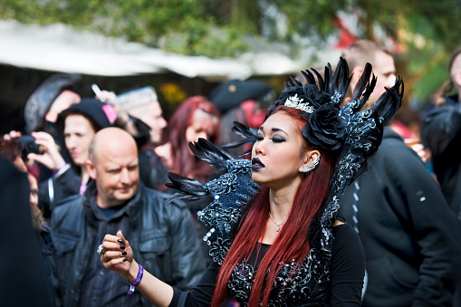 Leipzig, Germany - May 14, 2015: Young woman clad in a fantasy costume. Visitors of the annual Wave Gothic Meeting in Leipzig. Every year on Pentecost thousands of fans of the gothic subculture are celebrating one of the biggest music and cultural festivals of its kind worldwide. Everybody tries to dress up more sexy or curious than everyone else. The shot has been taken on the AGRA fairgrounds.