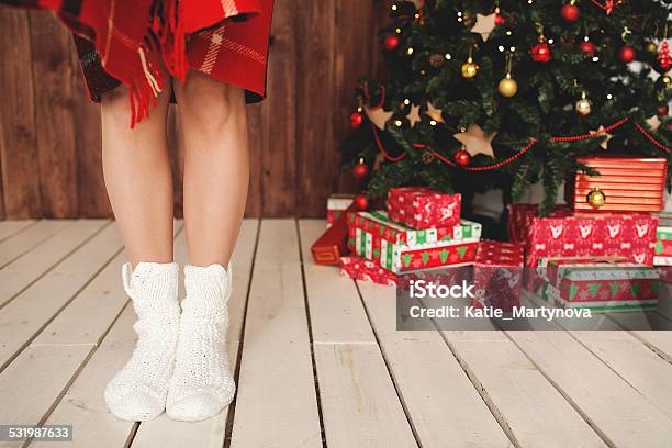 Woman Standing In Socks At Decorated Christmas Tree Stock Photo - Download Image Now