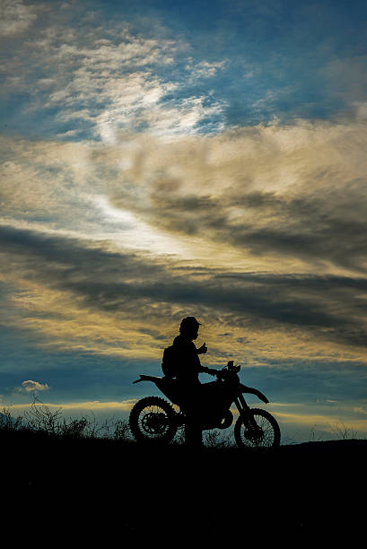 silhouetted motociclista ao pôr do sol - motorsprot imagens e fotografias de stock