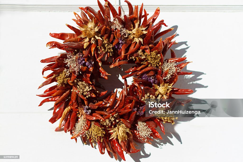 Santa Fe Style: Red Chili Pepper Wreath On White Door A red chili pepper wreath hangs on a white door in Santa Fe, NM.  Some copy space available. Wreath Stock Photo