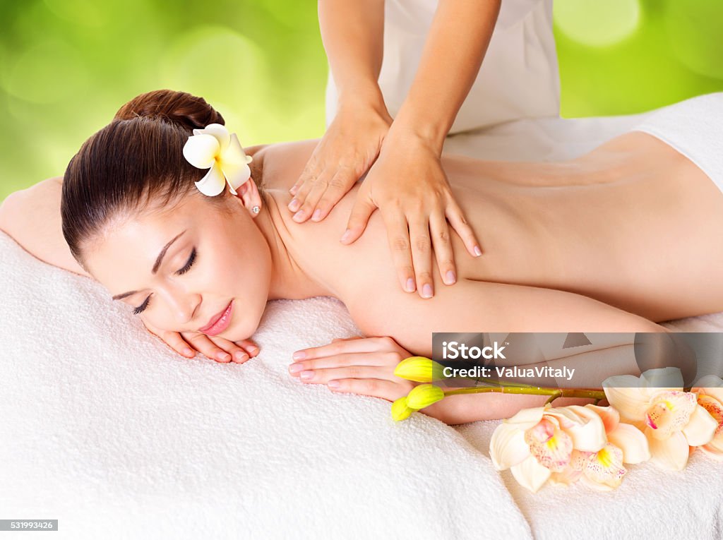Woman having massage of body in nature spa Woman having massage of body in the spa salon over green nature background Adult Stock Photo