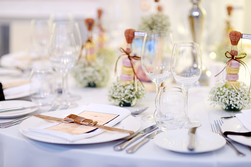 Elegant wedding banquet with golden vases, candlestick holders and little flower bouquets
