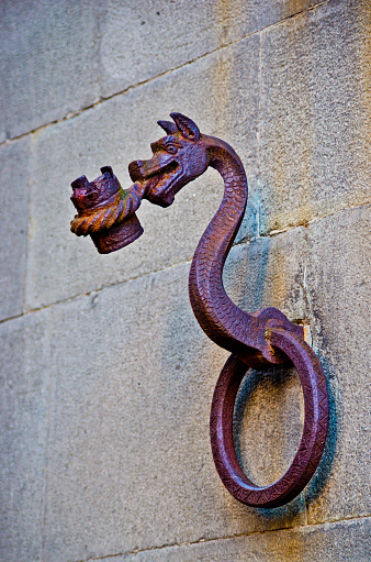 antique metal dragon is a bearer of a historic building