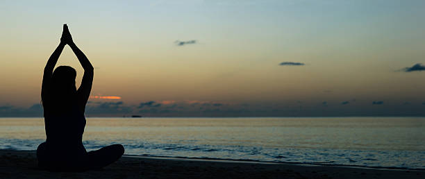 istock young woman doing yoga on sunset beach 531994032