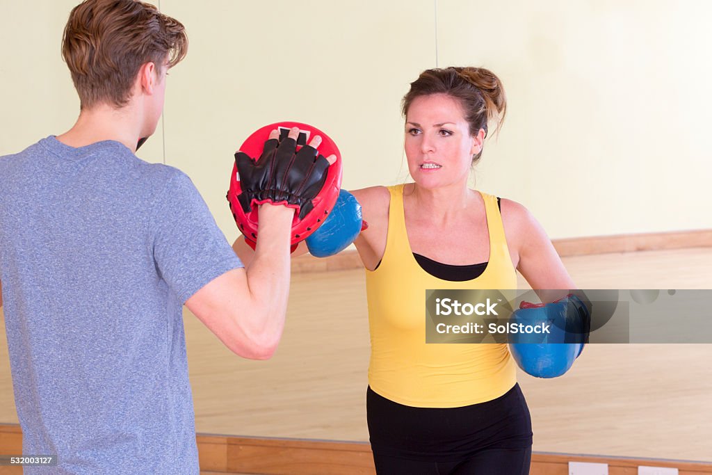 Female Kick Boxer with Trainer in Sparring Woman boxer practicing with his instructor. 2015 Stock Photo