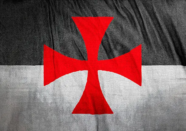 Flag of the Knights Templar on wrinkled cloth texture. The Poor Fellow-Soldiers of Christ and of the Temple of Solomon, commonly known as the Knights Templar, the Order of the Temple or simply as Templars, were among the most wealthy and powerful of the Western Christian military orders.