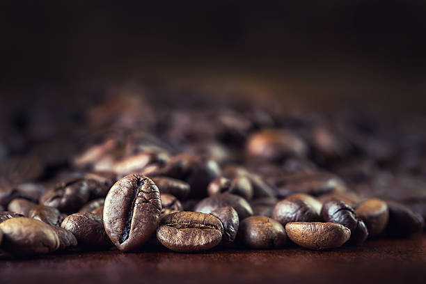 istock Roasted coffee beans spilled freely on a wooden table. 532008413