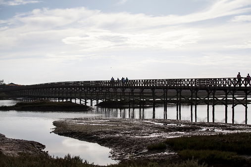Quinta do Lago, Portugal - September 20, 2014: People on a footbridge in National Park Ria Formosa, the bridge leads to the beach.