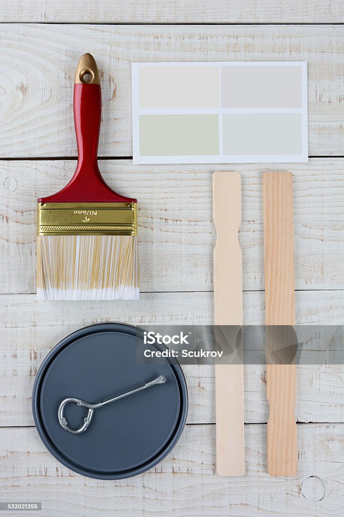 Painting Still Life Overhead shot of  a paint can lid, opener, color samples, stir sticks and paint brush on a rustic wooden surface. Vertical format with copy space. 2015 Stock Photo