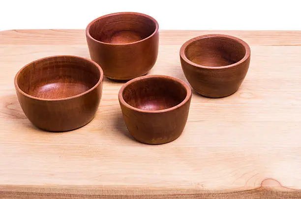 A group of four wooden bowls on a table or cutting board