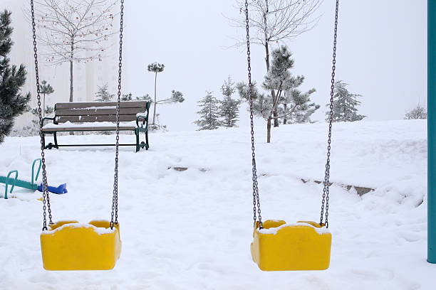 istock Swings in Snowy Playground 532025571
