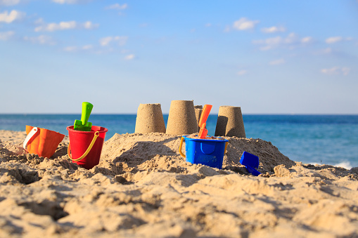 Sand castle on the beach with toys, family vacation