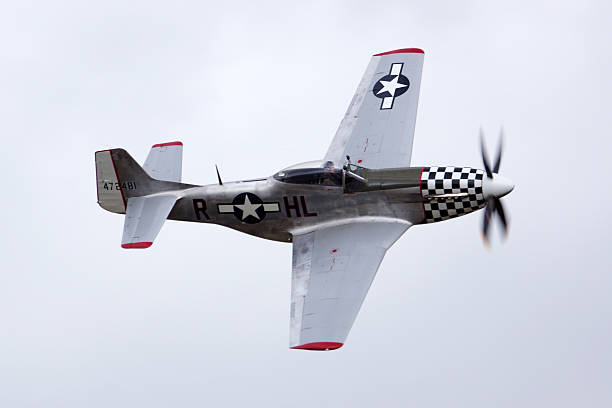 Airplane Vintage WWII P-51 Mustang fighter Chino,California,USA- April 30,2016. Vintage WWII P-51 Mustang fighter airplane flying at 2016 Planes of Fame Air Show in Chino, California. The 2016 Planes of Fame Air Show features vintage airplanes flying and 3 days of performing.  p 51 mustang stock pictures, royalty-free photos & images