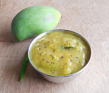 Raw mango curry in a steel bowl.