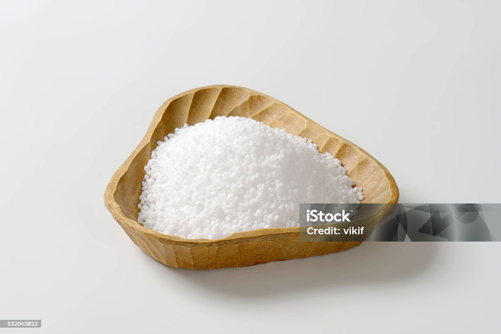 Coarse grained salt Coarse grained salt in triangle wooden bowl Alternative Therapy Stock Photo