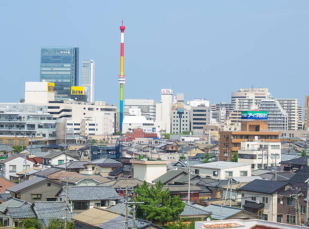 Approaching Niigata train station in Japan Top, side view from Shinkansen on a rural Japan town approaching Niigata train station with modern buildings in background. In front are small traditional houses with garden; common contrast in Japan. This is on west of Japan on main island Honshu near Japan Sea. niigata japan stock pictures, royalty-free photos & images