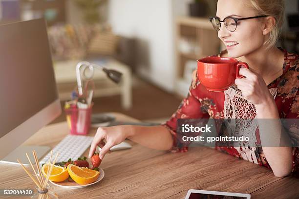 Little Snack Between Her Duties Stock Photo - Download Image Now - Snack, Healthy Eating, Home Office