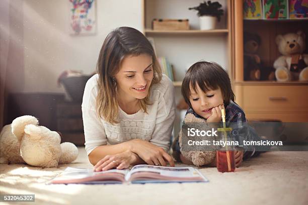 Young Mother Read A Book To Her Child Boy 照片檔及更多 地顫 照片 - 地顫, 母親, 兒子