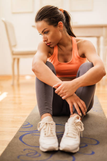 istock Pensive female athlete relaxing on the floor after exercising. 532048294