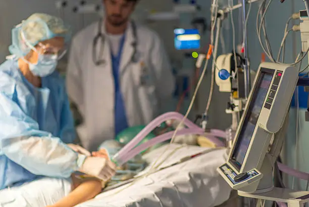 Doctor giving breathing apparatus to child patient in operating theatre.