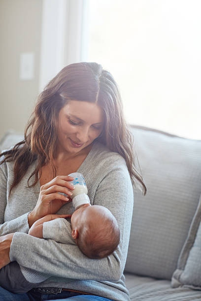 He loves his bottle Shot of a mother feeding her newborn baby infant feeding stock pictures, royalty-free photos & images