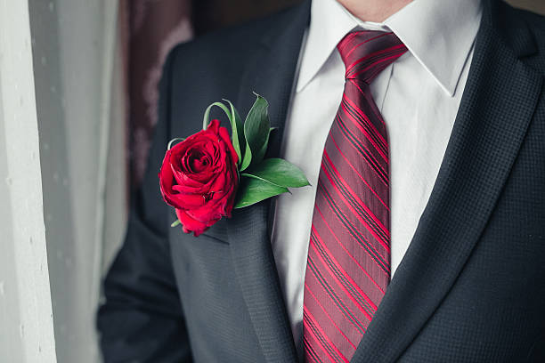 ojal de rosas rojas en la novia chaqueta de vestir en primer plano - boutonniere fotografías e imágenes de stock