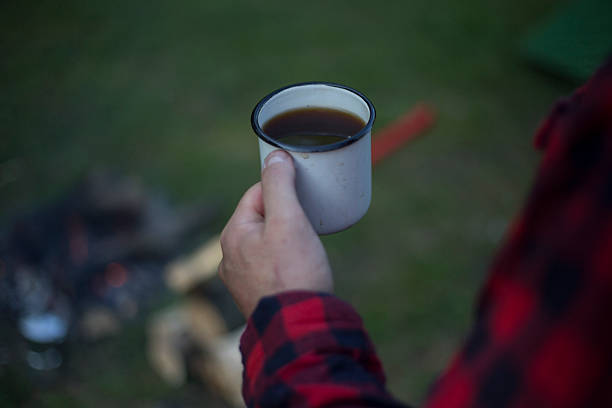 istock Man prepares coffee on a fire in a tent camp. 532050856