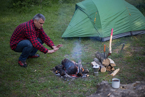 istock Man prepares coffee on a fire in a tent camp. 532051314