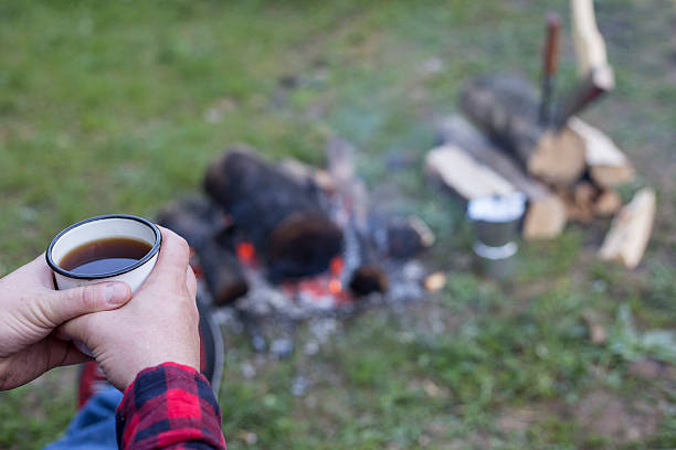istock Man prepares coffee on a fire in a tent camp. 532051920