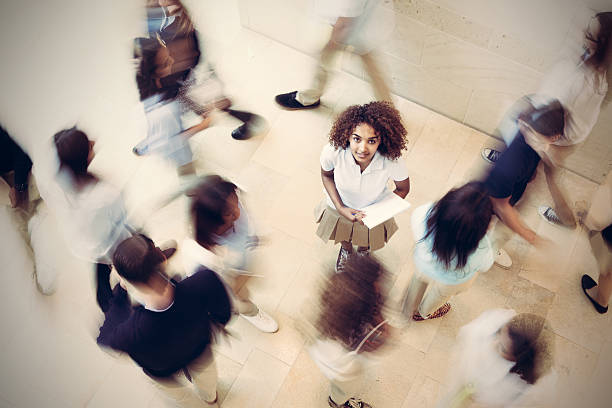 istock Nervous student standing still in busy private school hallway 532052841