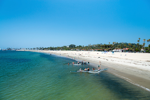 Santa Barbara, California, USA - May 25, 2014: People sunbathing, swimming and using canoe during a hot summer day at the Santa Barbara beach in California, USA.