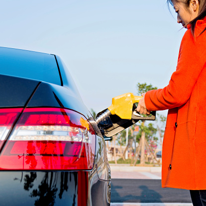 Woman hand filling fuel for her car.