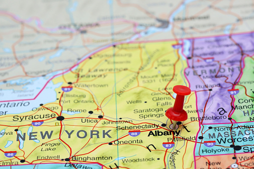 Photo of pinned Albany on a map of USA. May be used as illustration for traveling theme.