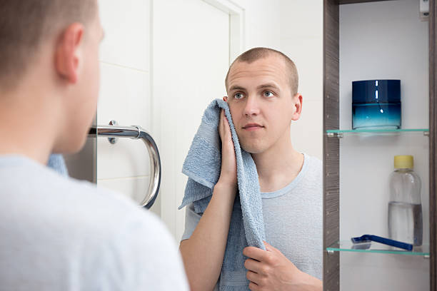 istock handsome man  looking at mirror after shaving in bathroom 532058846