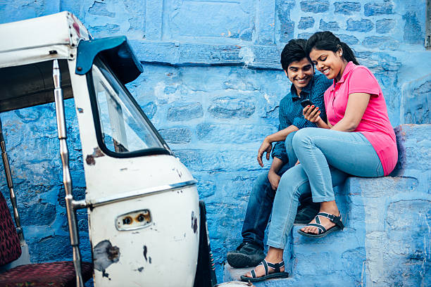 Young Indian Couple using Smartphone in Jodhpur Indian young couple using Smartphone in Blue City. India. auto rickshaw taxi india stock pictures, royalty-free photos & images
