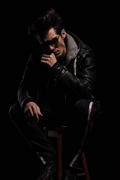 istock thoughtful young man in leather jacket sitting on chair 532059160