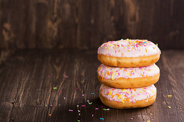 istock Three fresh sweet donuts over wooden table 532059374