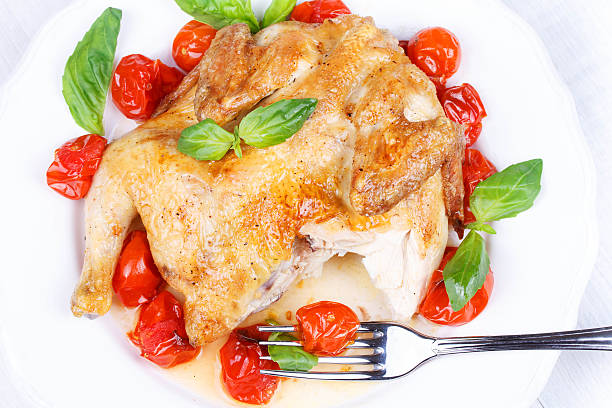 Roast chicken with tomatoes cherry, green basil and garlic