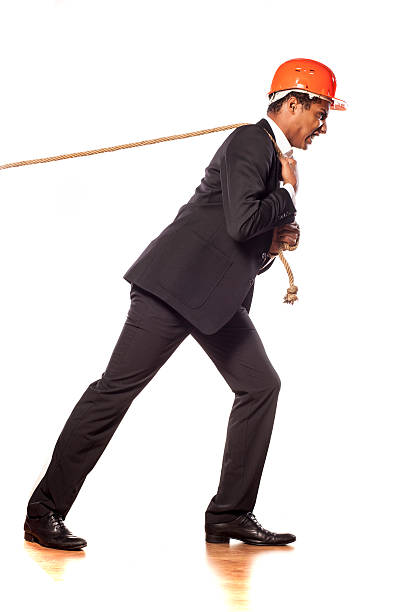 istock African businessman with a helmet pulling a rope 532093799