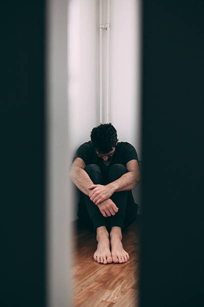 homem sentado sozinho e pressionar - men mental illness loss despair - fotografias e filmes do acervo