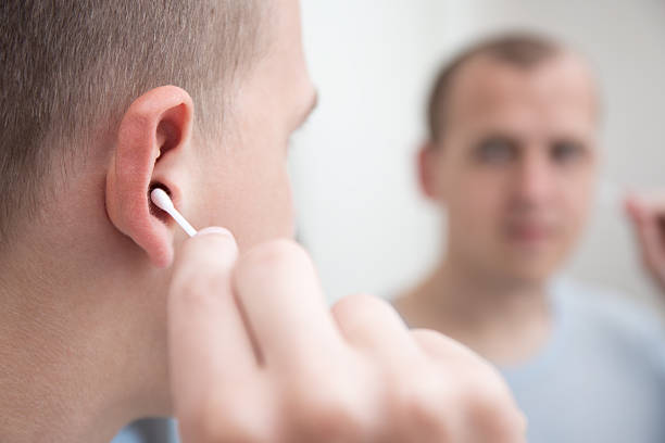 istock man cleaning his ear with a cotton swab 532108668