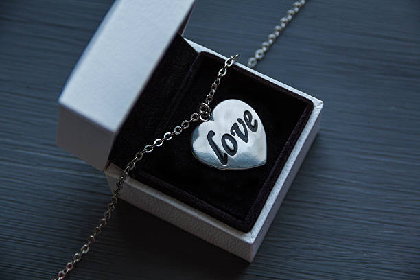 gift box and heart with the words love on wooden background