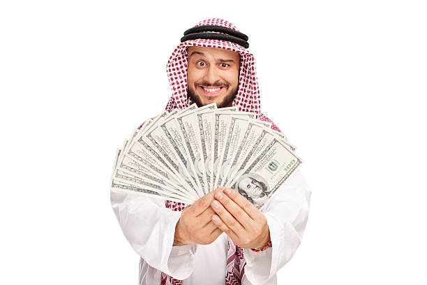 joyeux arabes tenant un pile d'argent - middle eastern ethnicity sheik wealth men photos et images de collection