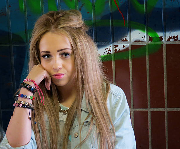 Tough teenage girl in an urban location wearing a septum in her nose.