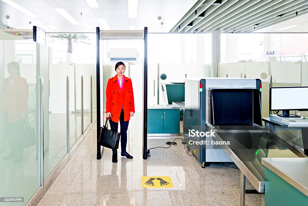 airport security checkpoint Female passenger walking through the airport security checkpoint 2015 Stock Photo